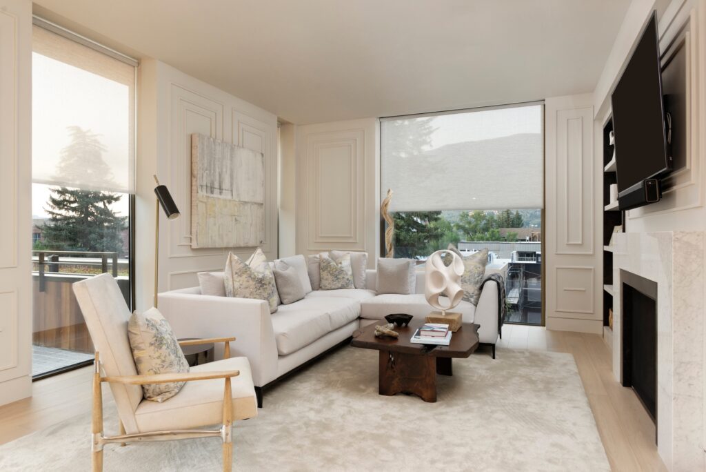 Luxury living room featuring automated shades and smart climate control for energy efficiency and convenience.